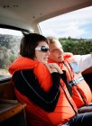 Усміхнена пара в рятувальних жилетах під час подорожі на човні — стокове фото