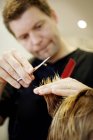 Vista de perto do homem cortando cabelo na barbearia — Fotografia de Stock