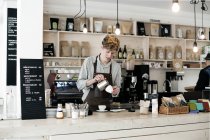 Junger Barista bereitet Cappuccino zu — Stockfoto