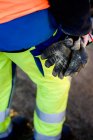 Construction worker holding messy gloves — Stock Photo