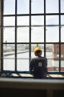 Trabalhador da construção em pé à janela — Fotografia de Stock