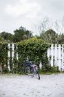Bicycle parked by fence — Stock Photo