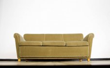 Canapé contre mur blanc — Photo de stock