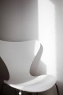 Moderner weißer Stuhl gegen Wand — Stockfoto