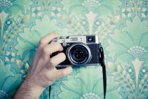 Cortado mão segurando câmera vintage — Fotografia de Stock