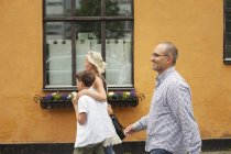 Famiglia che cammina contro edificio arancione — Foto stock