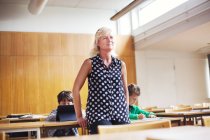 Teacher standing in front of students — Stock Photo