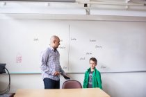 Вчитель розмовляє зі школярем у класі — стокове фото