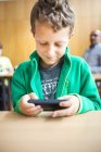 Schoolboy using smart phone — Stock Photo