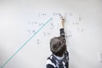 Boy writing on whiteboard — Stock Photo