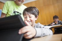 Rapaz feliz usando tablet digital — Fotografia de Stock