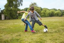 Schoolboys playing soccer — Stock Photo