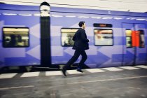 Businessman running on platform — Stock Photo