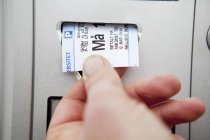 Hand zieht Fahrkarte aus Automat — Stockfoto