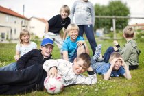 Felice scolari con palloni da calcio — Foto stock