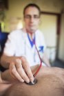 Médico posicionamento estetoscópio no paciente masculino — Fotografia de Stock