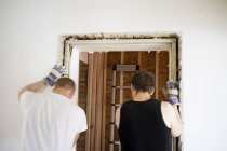Carpinteiros trabalhando na moldura da porta — Fotografia de Stock