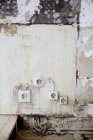 Damaged outlets on weathered wall — Stock Photo