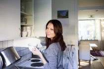 Femme heureuse tenant tasse de café — Photo de stock