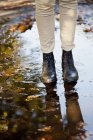 Woman walking on puddle — Stock Photo