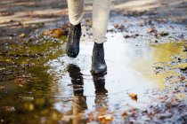Woman walking on puddle — Stock Photo