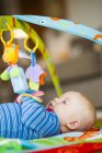 Boy playing with hanging mobile — Stock Photo