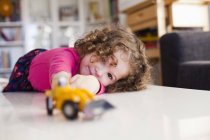 Cute girl playing with toy car — Stock Photo