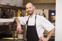 Chef feliz de pé na cozinha comercial — Fotografia de Stock