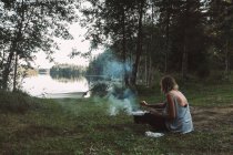 Donna barbecue vicino al lago — Foto stock