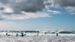 Молоді люди, серфінг в море — стокове фото