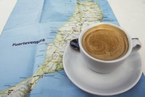 Tazza di caffè fresco sulla mappa — Foto stock