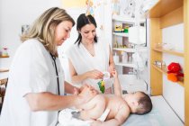 Médecin examinant bébé — Photo de stock