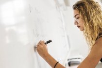 Schüler schreiben auf Whiteboard — Stockfoto