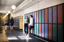 Jóvenes estudiantes de pie en el pasillo - foto de stock