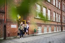 Young Students leaving school — Stock Photo