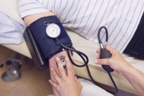 Médico midiendo presión arterial - foto de stock