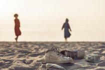 Dos mujeres de pie en la playa - foto de stock