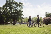 Mulheres de pé com bicicletas — Fotografia de Stock
