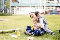 Mãe com filhos sentados na grama — Fotografia de Stock