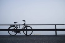 Bicicleta abandonada tras barandilla - foto de stock