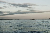 Морской пейзаж с силуэтом гребной лодки — стоковое фото