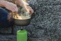 Man preparing food on camping stove — Stock Photo