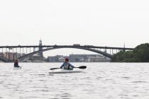 Mujer kayaking on river - foto de stock