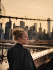 Femme debout sur le pont et regardant loin — Photo de stock