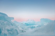 Замерзший лед с заснеженной горой — стоковое фото