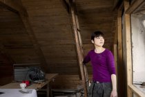Donna in piedi in vecchia soffitta — Foto stock