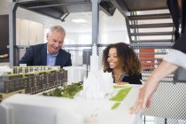 Architects looking at buildings model — Stock Photo