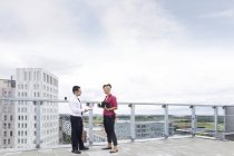 Man and woman talking on rooftop — Stock Photo