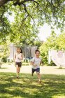 Crianças correndo no jardim verde — Fotografia de Stock