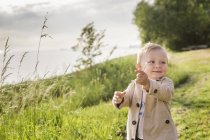 Мальчик ходит по зеленому лугу — стоковое фото